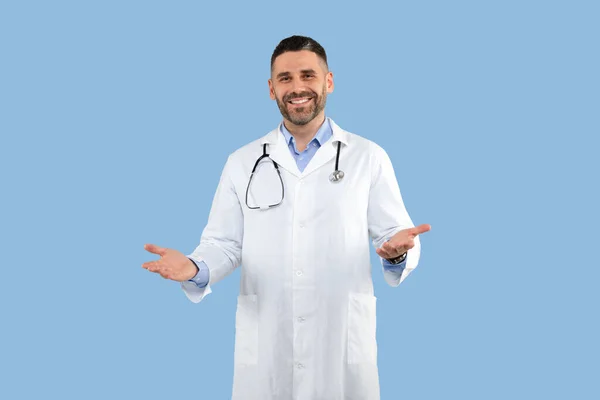 青いスタジオの背景 コピースペースの上に聴診器笑顔とジェスチャー歓迎正の中年男性医師 医療スタッフのコンセプト — ストック写真