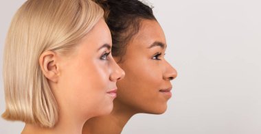 İki çok ırklı genç kadın Afro-Amerikan ve sarışın beyaz arka planda makyajsız kusursuz temiz cilde sahip beyaz afiş, afiş, kolaj...