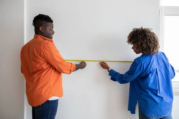 Happy Black Couple Measuring White Wall Tape Ruler While Making — Stock Photo, Image