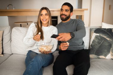 Gülen, çok kültürlü genç bir çift kanepeye oturur, birlikte boş vakit geçirir, uzaktan kumandayla televizyon izler, oturma odasının içinde patlamış mısır yer. Film akşamı, evde dinlenme, aşk ve ilişki.