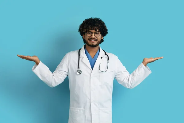 Веселий Позитивний Молодий Індійський Лікар Тримає Щось Невидиме Обох Руках — стокове фото