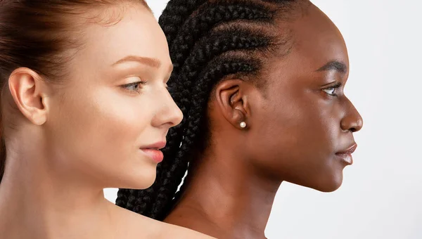 Diversity in beauty. Sensual dark-skinned and pale red-haired half-naked females young women posing on white studio background, looking at copy space, closeup, banner, collage