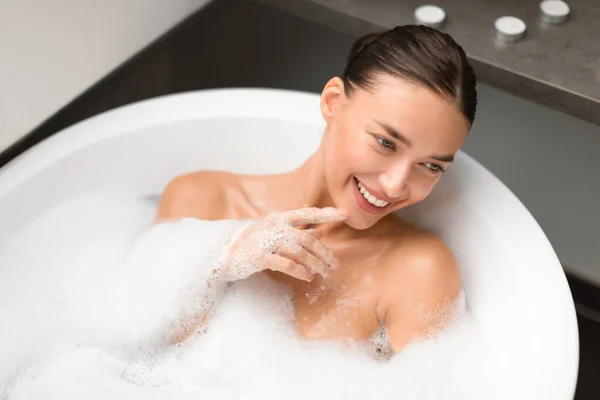 Jonge Vrouw Badend Het Water Met Schuim Ontspannen Witte Badkuip — Stockfoto