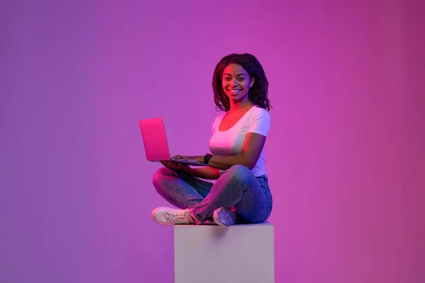 Šťastná Černošky Žena Notebookem Sedí Velké Kostky Neonovém Osvětlení Usmívající — Stock fotografie
