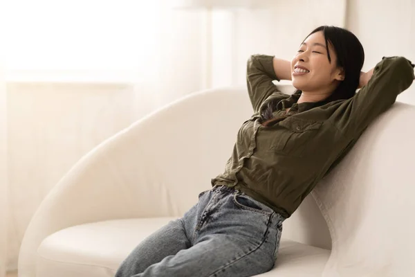 快適なカジュアルな服装で美しい魅力的な若いアジアの女性リラックスしたソファの上でリビングルーム 自宅で週末を過ごす韓国語の女性をリラックスし 閉じた目でソファにリクライニング コピースペース — ストック写真