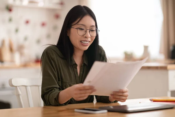 Šťastná Mladá Asiatka Brýlemi Sedící Kuchyňským Stolem Notebookem Telefonem Držící — Stock fotografie