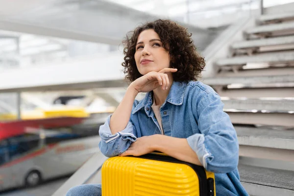 Travel Plan. Pensive Young Female With Suitcase Waiting At Airport, Dreamy Millennial Woman Sitting On Stairs In Terminal And Looking Away, Planning Travel Route, Closeup Shot With Copy Space