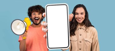 Çevrimiçi teklif. Heyecanlı Hintli Adam Megafon Kullanırken Genç Kadın Beyaz Ekranlı Büyük Boş Akıllı Telefonu Tutarken, Mobil Reklam, Kolaj, Mobil Maket İçin Kopya Alan Gösteren Çok Irklı Çift