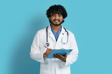 İş kıyafetleri bölümünde çalışan yakışıklı bir doktor. Elinde tıbbi dosya ve kalem var. Terapistin hastasıyla randevusu var.