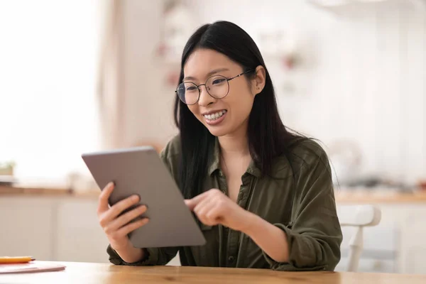 台所のデジタルタブレットで歯のブレースや眼鏡をかけ 明るく明るいアジアの若い女性が 家庭で働く女性経営者 コピースペース リモートジョブフリーランス — ストック写真