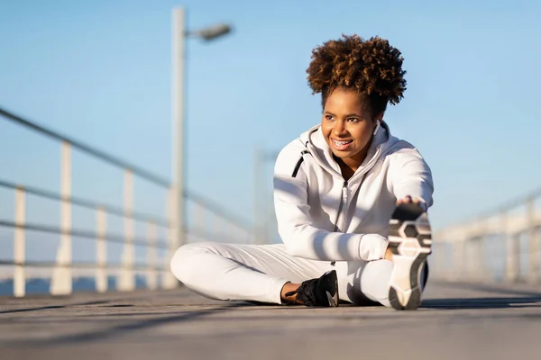 stock image Fitness Lifestyle. Sporty Black Female Training Outdoors On Wooden Pier, Athletic Young African American Woman In Sportswear Stretching Leg Muscles, Getting Ready For Jogging Outside, Copy Space