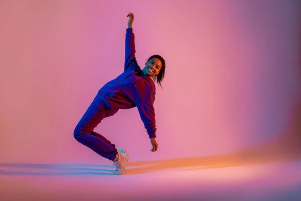 趣味で踊る ピンク色のネオンを背景にダンスの感情を表現するアフリカ系アメリカ人女性ヒップホップダンサー ダンス ダイナミクス アクションの概念 — ストック写真