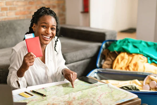 Ready for vacation. Excited african american woman holding passports with tickets and choosing new country for travel destination, preparing for future travel