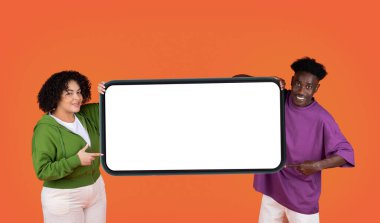 Pozitif, sevimli, güzel, melez bir çift, İspanyol bir kadın, iri yarı, elinde beyaz ekranlı, siyah bir adam, flört uygulaması için model, kırmızı arka plan.