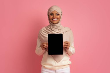 Başörtüsü İçinde Gülen Müslüman Kadın Boş Siyah Ekran ile Dijital Tablet Tutuyor, Başörtüsü Giyen Mutlu İslami Kadın Uygulama veya Web Sitesi Tasarımı İçin Kopya Alanı Gösteriyor, Pembe Arkaplan,