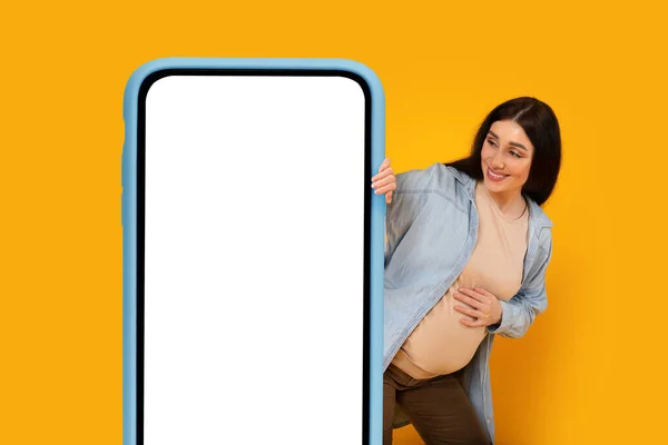 Happy Young Pregnant Lady Peeking Out Huge Blank Smartphone Looking — Stock Photo, Image