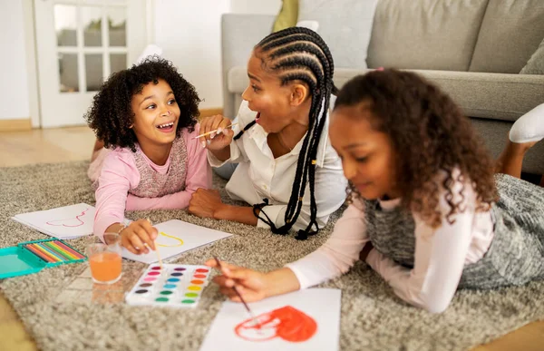 快乐的非洲裔美国母亲和女儿在家里的现代客厅里画着自己的脸 画着自己的脸 周末休闲 家庭活动 选择性焦点 — 图库照片
