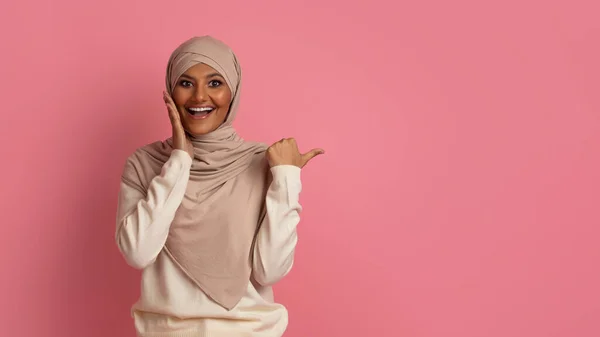 Niesamowita Oferta Podekscytowana Młoda Muzułmanka Hidżabie Wskazująca Przestrzeń Kciukiem Górze — Zdjęcie stockowe