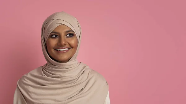 穿着头巾 头戴全景图 站在粉红工作室背景上的漂亮穆斯林妇女的肖像 照片中的中东女性穿着头巾 头戴全景图 站在复印空间旁边 — 图库照片