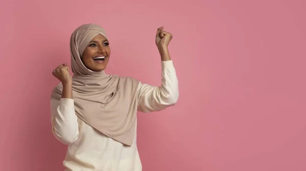 Överlycklig Muslimsk Kvinna Firar Framgång Skakar Knytnävar Och Tittar Sidan — Stockfoto