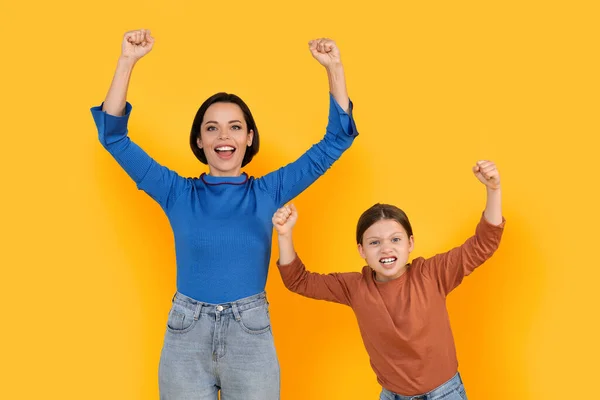 Aufgeregte Junge Mutter Und Kleine Tochter Feiern Erfolg Vor Gelbem — Stockfoto