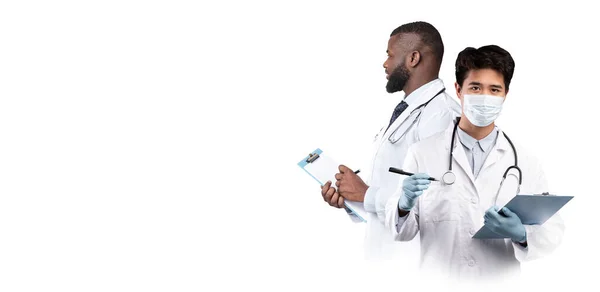 白い背景に隔離された立ち手にクリップボードを持つ2人の多民族男性医師 コラージュ パノラマでチェックするための制服を着た多文化療法士 — ストック写真