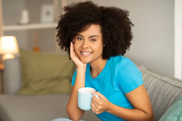 Sonriente Joven Rizado Mujer Afroamericana Con Taza Bebida Caliente Sienta —  Fotos de Stock