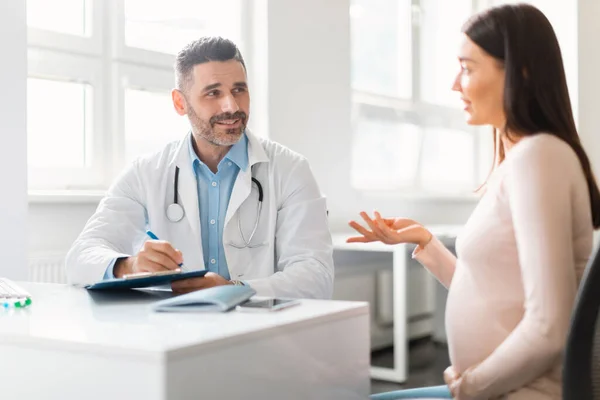 Young Pregnant Woman Sitting Hospital Talking Having Consultation Middle Aged — Stock Photo, Image