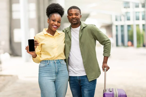 Happy Black Spouses Publicidad Aplicación Viaje Mostrando Smartphone Con Pantalla —  Fotos de Stock