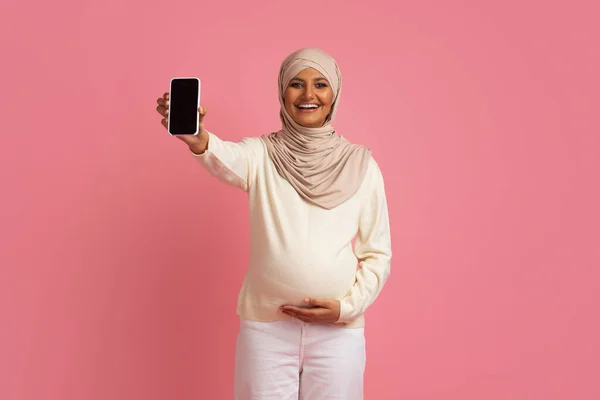 Wanita Muslim Hamil Dalam Hijab Menyentuh Belly Dan Menunjukkan Smartphone — Stok Foto