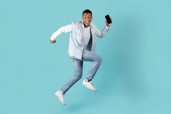 Cheerful Excited Millennial Black Guy Open Mouth Running Jumping Smartphone — Stock Photo, Image