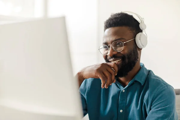 Šťastný Afroameričan Bezdrátových Sluchátkách Pracující Počítači Sledující Webinář Dívající Obrazovku — Stock fotografie