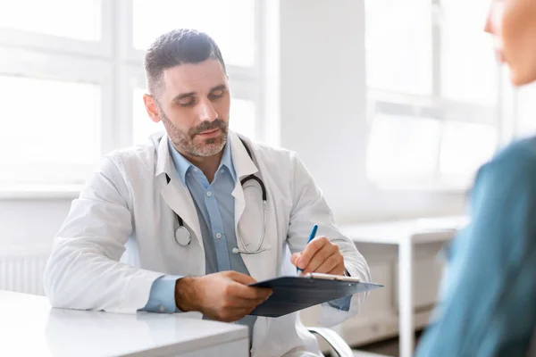 Ärztin Hört Patientin Bei Konsultation Büro Aufmerksamer Männlicher Therapeut Notiert — Stockfoto