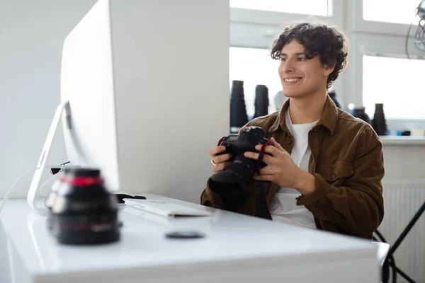 Hombre Fotógrafo Profesional Feliz Sosteniendo Cámara Mirando Monitor Computadora Sentado — Foto de Stock