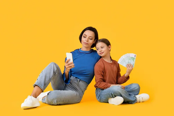 Mutter Und Tochter Mit Smartphone Und Euro Bargeld Sitzen Isoliert — Stockfoto