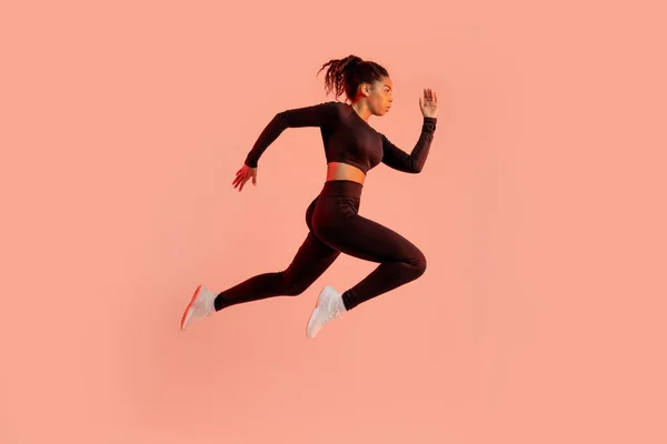 Sportieve Zwarte Dame Springen Rennen Poseren Lucht Oefenen Perzik Neon — Stockfoto