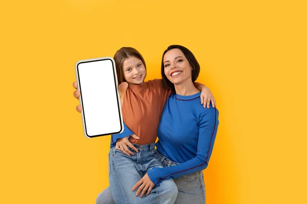 Lächelnde Junge Mutter Und Kleine Tochter Demonstrieren Smartphone Mit Leerem — Stockfoto
