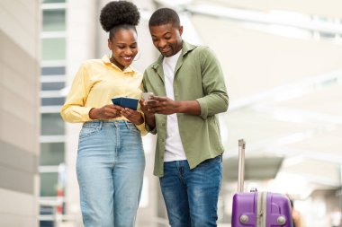 Gezici Başvuru Biletlerinde, Havalimanı Havalimanı 'ndaki bavulda duran akıllı telefon tutan çift pasaport tutuyor. Teknoloji ve Turizm Konsepti