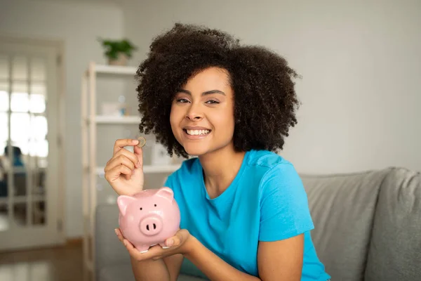 Vrolijke Duizendjarige Afrikaans Amerikaanse Krullende Vrouw Zet Geld Piggy Bank — Stockfoto