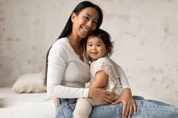 Felice Mamma Coreana Abbracciare Sua Adorabile Figlia Infantile Seduta Camera — Foto Stock