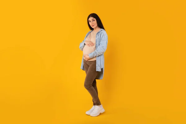 Full Length Portrait Beautiful Pregnant Lady Embracing Belly Looking Camera — Stock Photo, Image