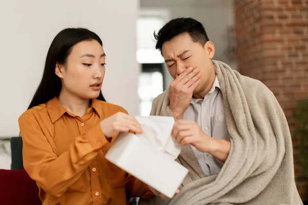爱韩国的年轻妻子照顾生病的中年丈夫 女人把餐巾纸送给男人 坐在客厅的沙发上 季节性过敏和鼻炎 — 图库照片