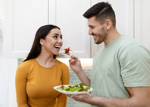 행복하게 남자가 머리로 여자에게 음식을 제공하고 남편은 건강에 샐러드를 아내에게 — 스톡 사진