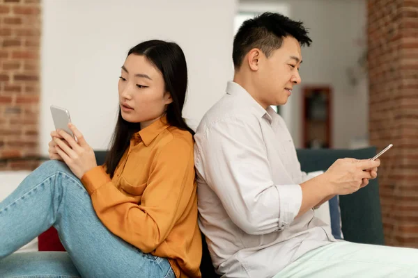 婚姻危机 韩国配偶用手机 背靠背坐在沙发上 彼此冷漠 相形见绌 相亲相爱 — 图库照片