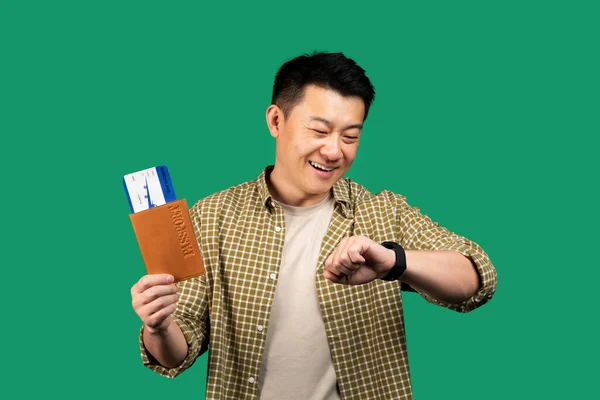 Щасливий Азіатський Чоловік Тримає Паспорт Квитками Дивлячись Годинник Посміхаючись Перевіряючи — стокове фото