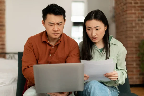 忧心忡忡的亚洲中年男子和年轻女子坐在笔记本电脑旁 检查账单 共同处理家庭预算 — 图库照片
