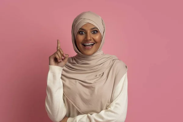 在Hijab的兴奋的穆斯林妇女在工作室 复制空间有想法 指出手指 带着令人兴奋的时刻头戴头巾站在粉红背景下 — 图库照片