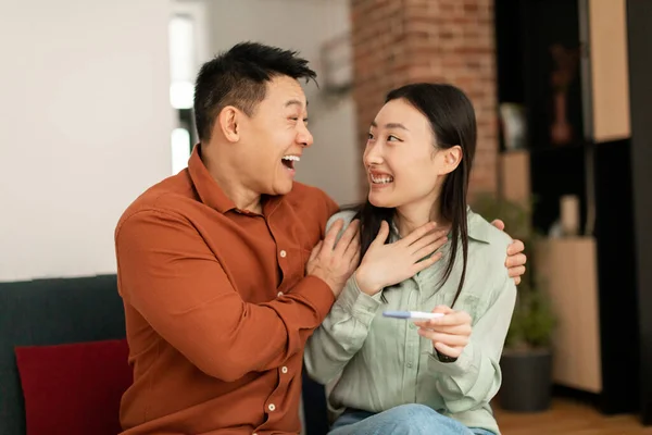 Happy Korean Couple Positive Pregnancy Test Hugging Celebrating Successful Childbearing — Stock Photo, Image