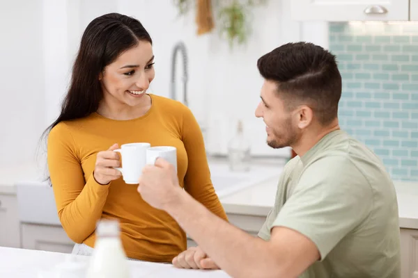 愛と人間関係 明るく幸せな美しい愛するヒスパニック系の若者と女性のカジュアルなキッチンで座って お茶やコーヒーを飲み 会話をし 家で一緒に時間を楽しむ — ストック写真
