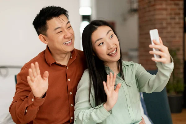 Portrait Cheerful Asian Married Spouses Using Cellphone Video Calling Waving — Stock Photo, Image